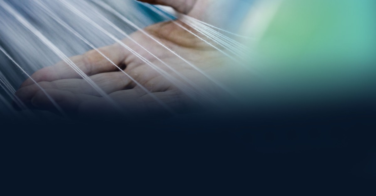 Expert hand holding technical fabric fibres illustrated with the SUBRENAT logo, French manufacturer and supplier of customised technical textiles